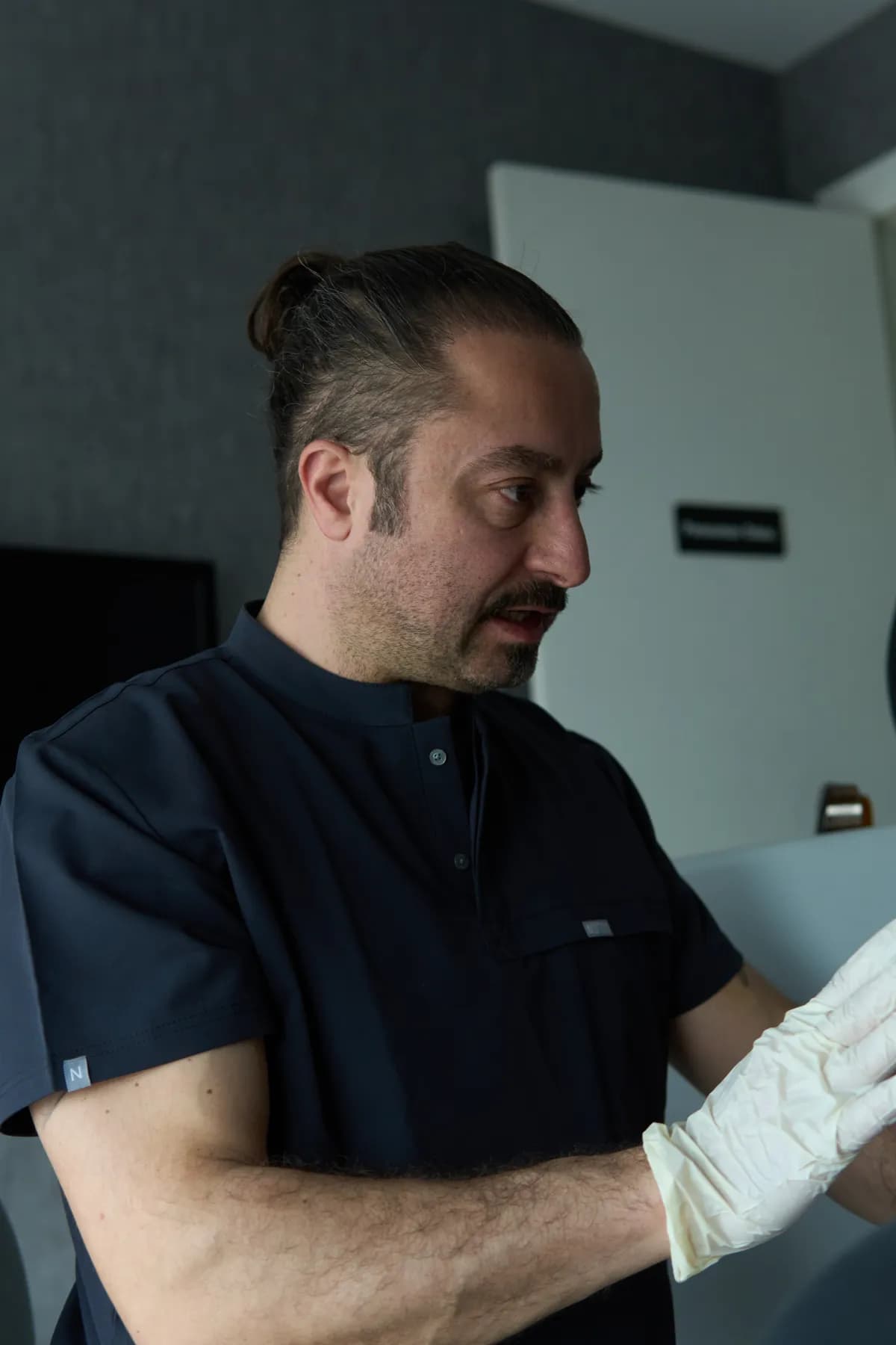 Uzm. Dr. Mehmet Karakuyu muayene sırasında dövmeyi değerlendiriyor
